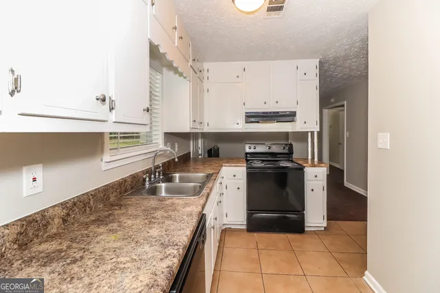 a kitchen with a sink stove and refrigerator