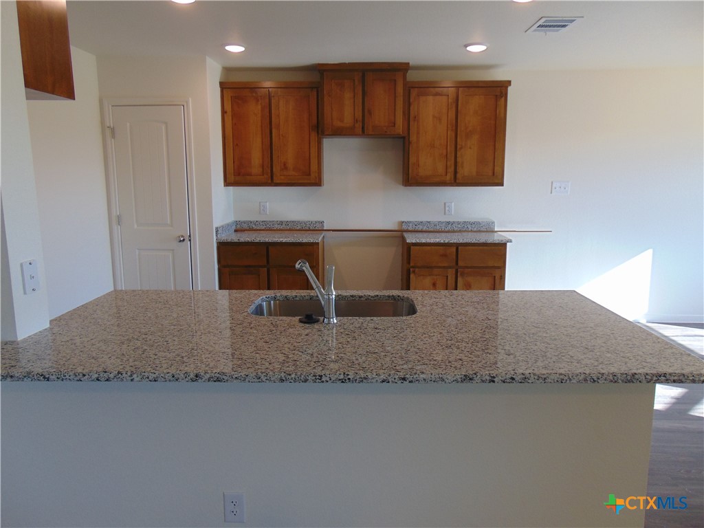 3202 Salt Fork Drive Killeen, TX 76549 - Photo 6 of 25 a kitchen with kitchen island granite countertop a sink and a stove top oven