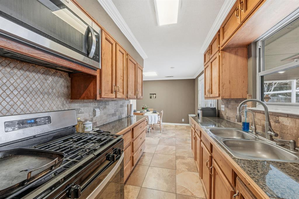 1530 Carson Drive Mesquite, TX 75149 - Photo 11 of 21 a kitchen with granite countertop a sink a stove and cabinets