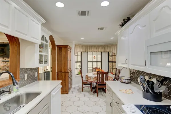a kitchen with a sink stove and chairs