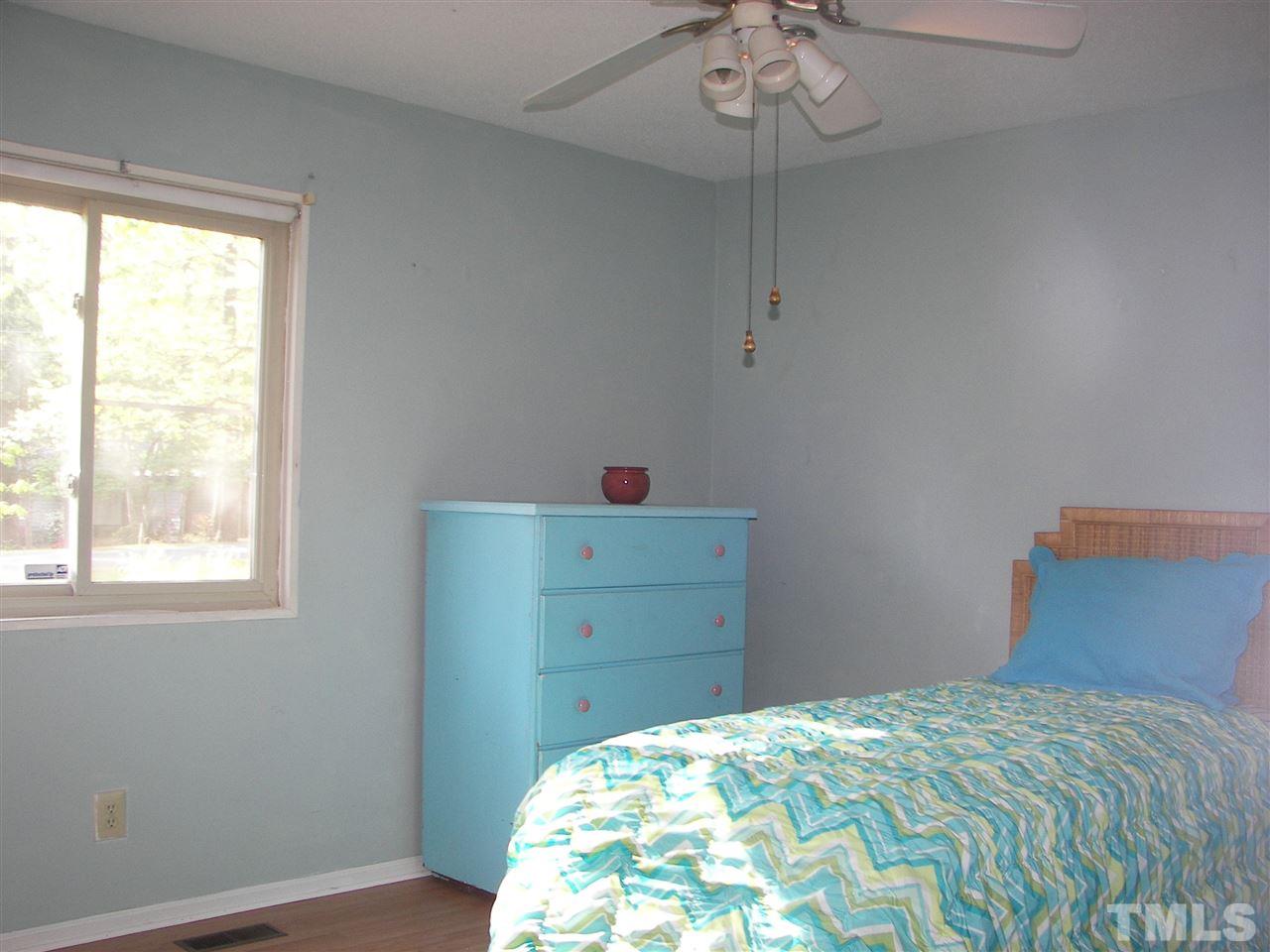 5016 Raintree Road Durham, NC 27712 - Photo 20 of 22 a bedroom with a bed and a chandelier