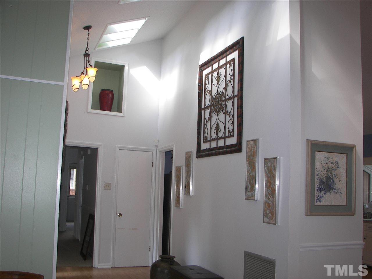 5016 Raintree Road Durham, NC 27712 - Photo 6 of 22 a view of a hallway with paintings on the wall