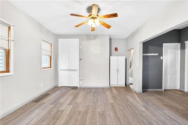 a view of a kitchen with a sink a refrigerator a ceiling fan and wooden floor