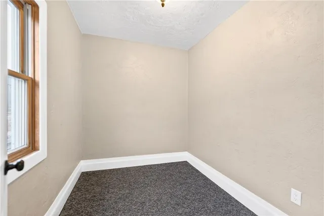 an empty room with windows and ceiling fan