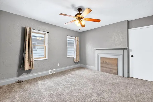 an empty room with closet and a ceiling fan