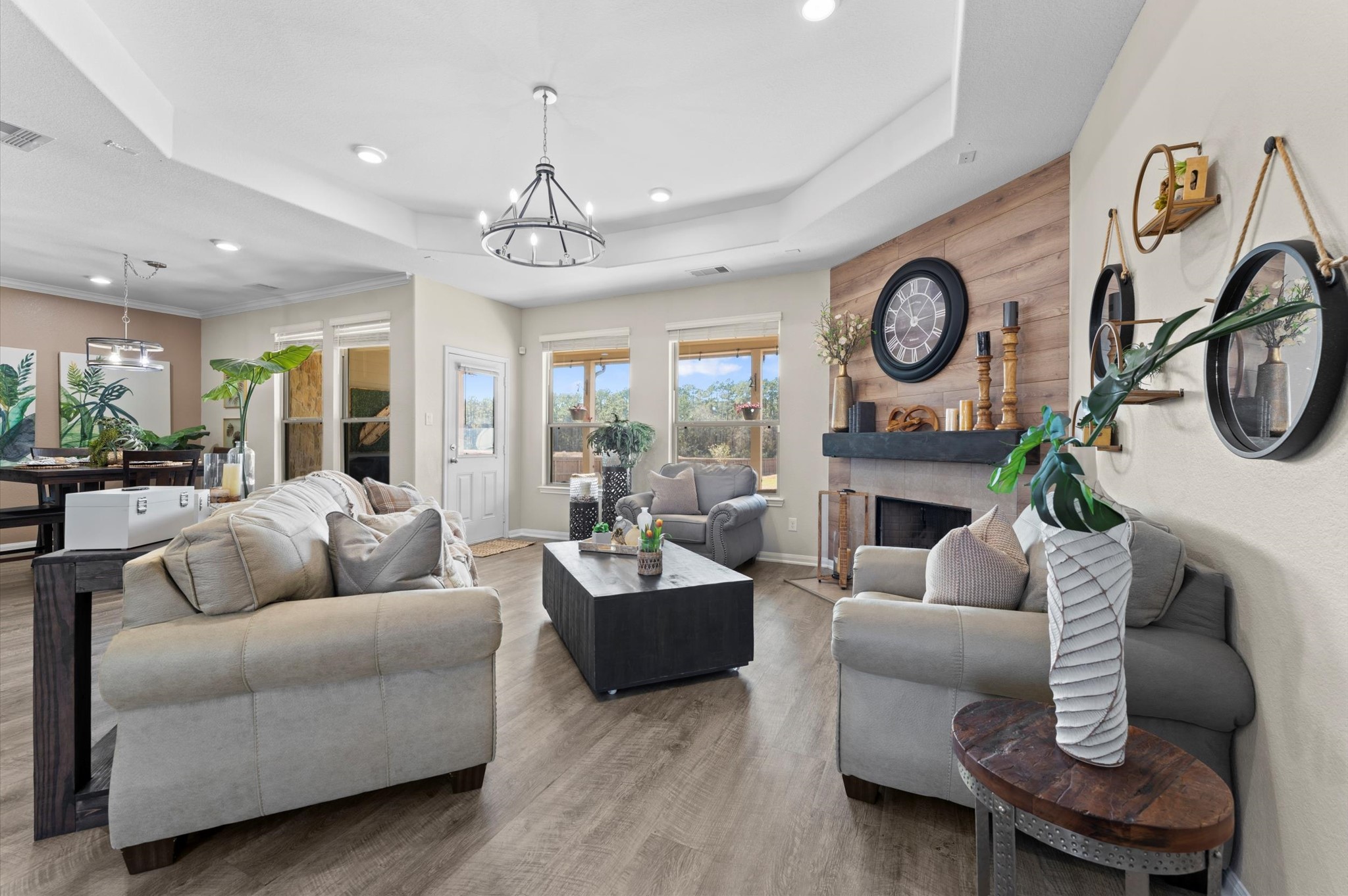 9729 Hidalgo Street Conroe, TX 77303 - Photo 13 of 38 Inviting living room features a cozy fireplace with a decorative wood accent and abundant natural light from large windows. The open layout seamlessly connects to the dining area, creating a perfect space for entertaining.