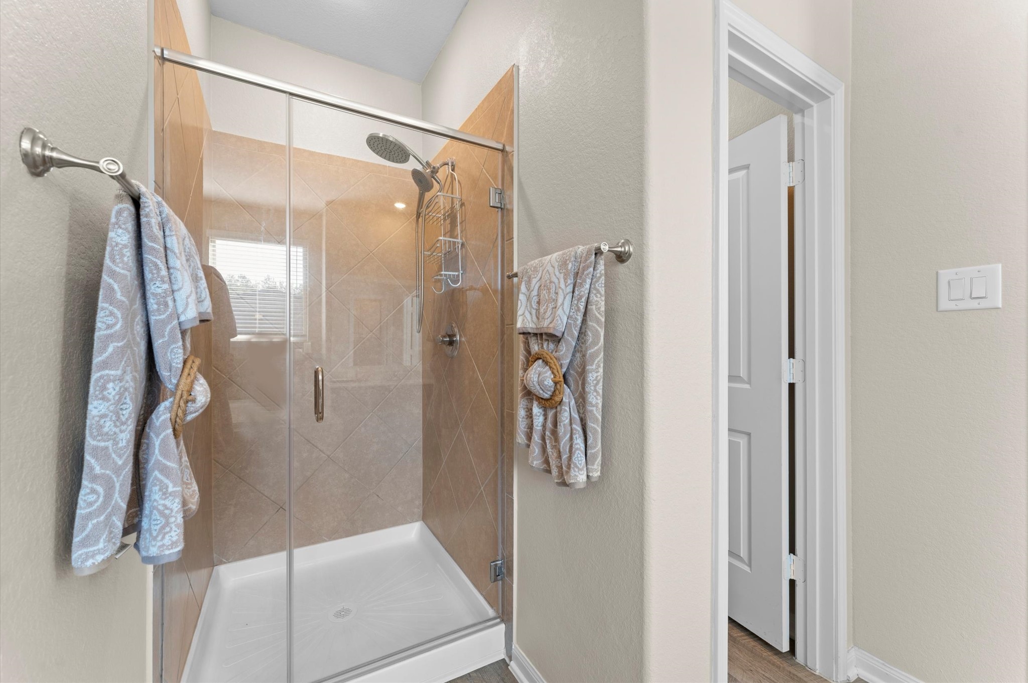 9729 Hidalgo Street Conroe, TX 77303 - Photo 22 of 38 The primary en-suite separate glass-enclosed shower, tiled walls, and neutral tones. Features dual towel racks and a bright, clean design.