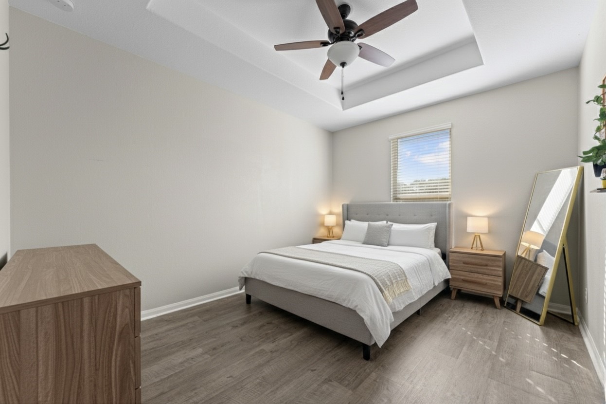 9729 Hidalgo Street Conroe, TX 77303 - Photo 27 of 38 This virtually staged bedroom offers a look at the potential for a warm, inviting atmosphere with it's stylish ceiling fan and wood-like vinyl flooring, perfect for creating your personal haven.