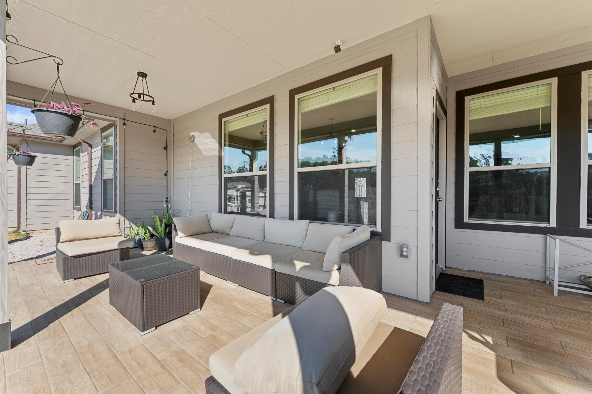 9729 Hidalgo Street Conroe, TX 77303 - Photo 31 of 38 The other side of the cozy, covered patio. Ideal for relaxing or entertaining, it features wood-like tile flooring and neutral tones, creating an inviting atmosphere.
