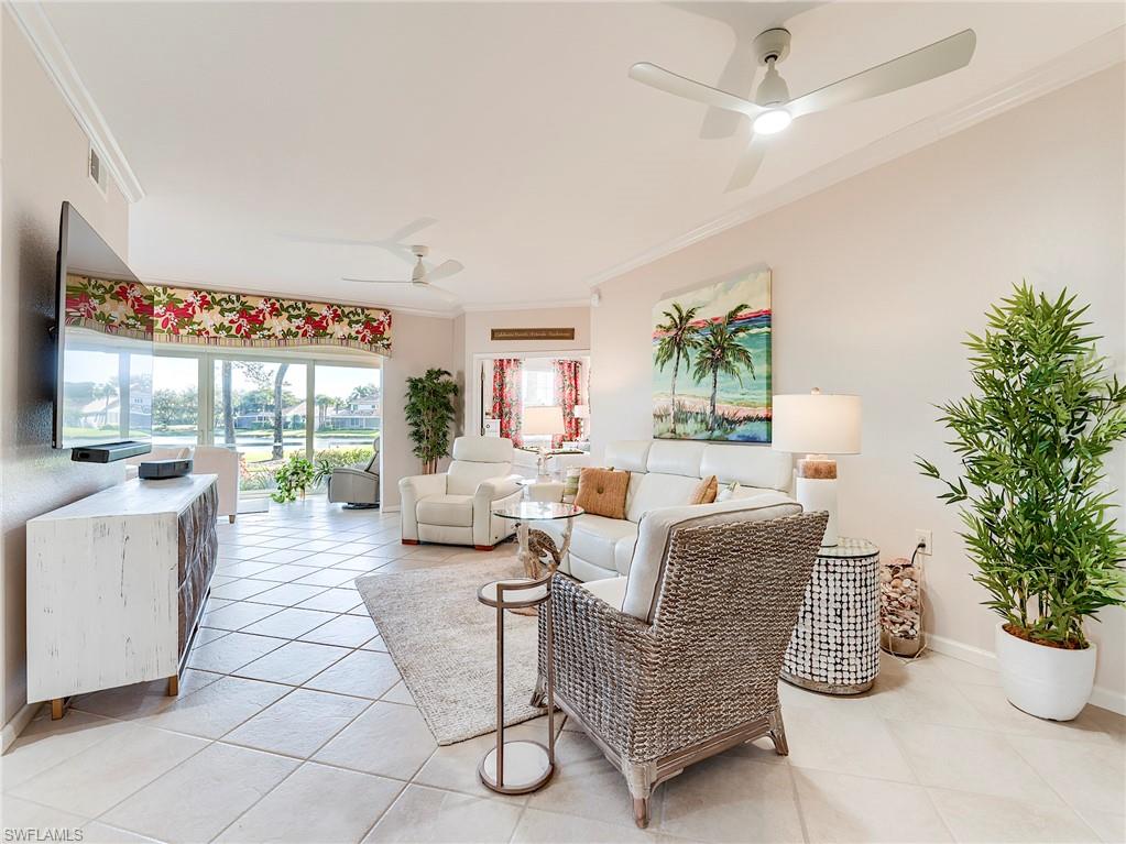 23011 Rosedale Drive, Unit 101 Estero, FL 34135 - Photo 15 of 34 a living room with furniture a chandelier and a potted plant