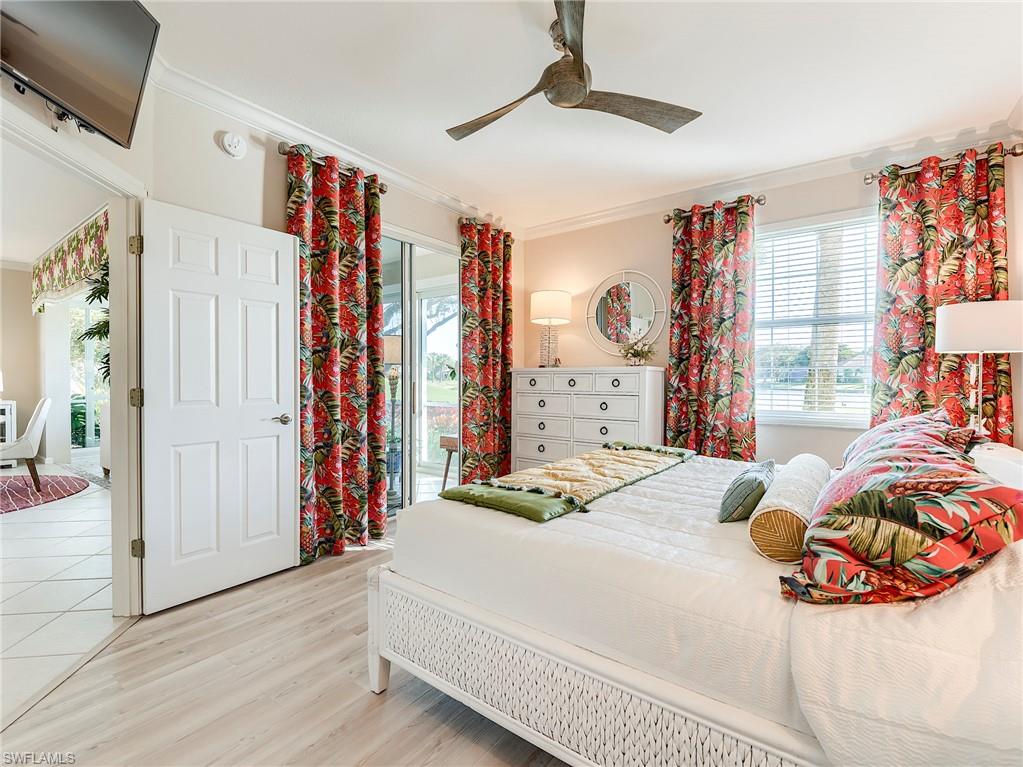 23011 Rosedale Drive, Unit 101 Estero, FL 34135 - Photo 21 of 34 a bedroom with a large bed and a chandelier