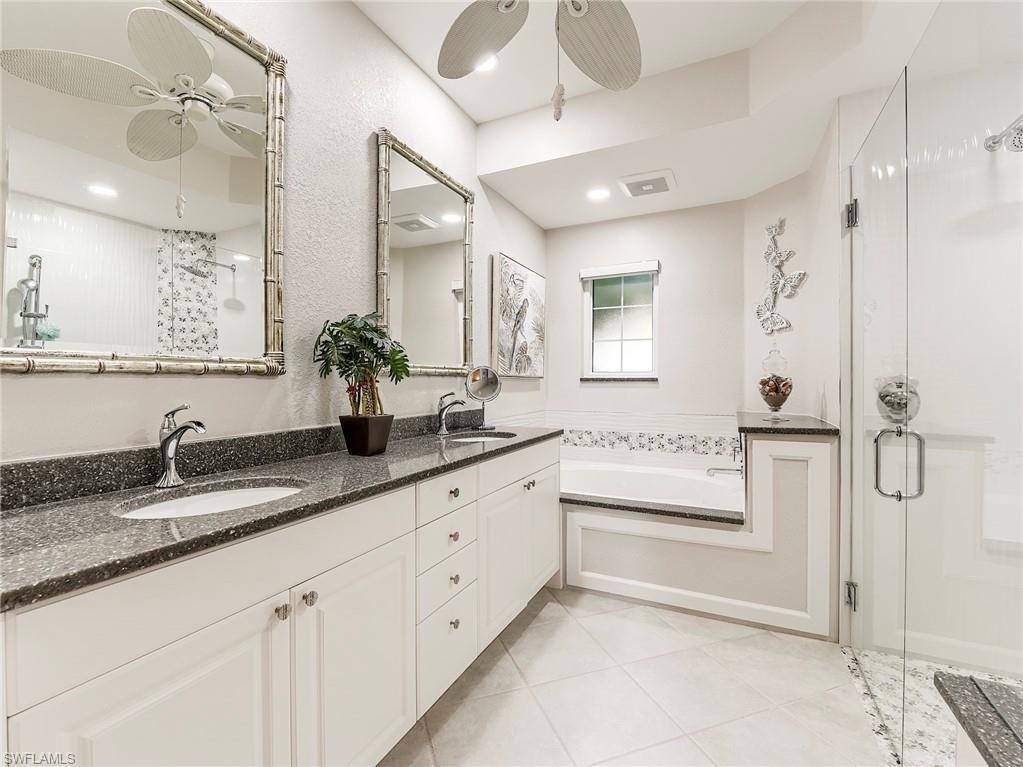 23011 Rosedale Drive, Unit 101 Estero, FL 34135 - Photo 23 of 34 a bathroom with a granite countertop sink mirror and shower