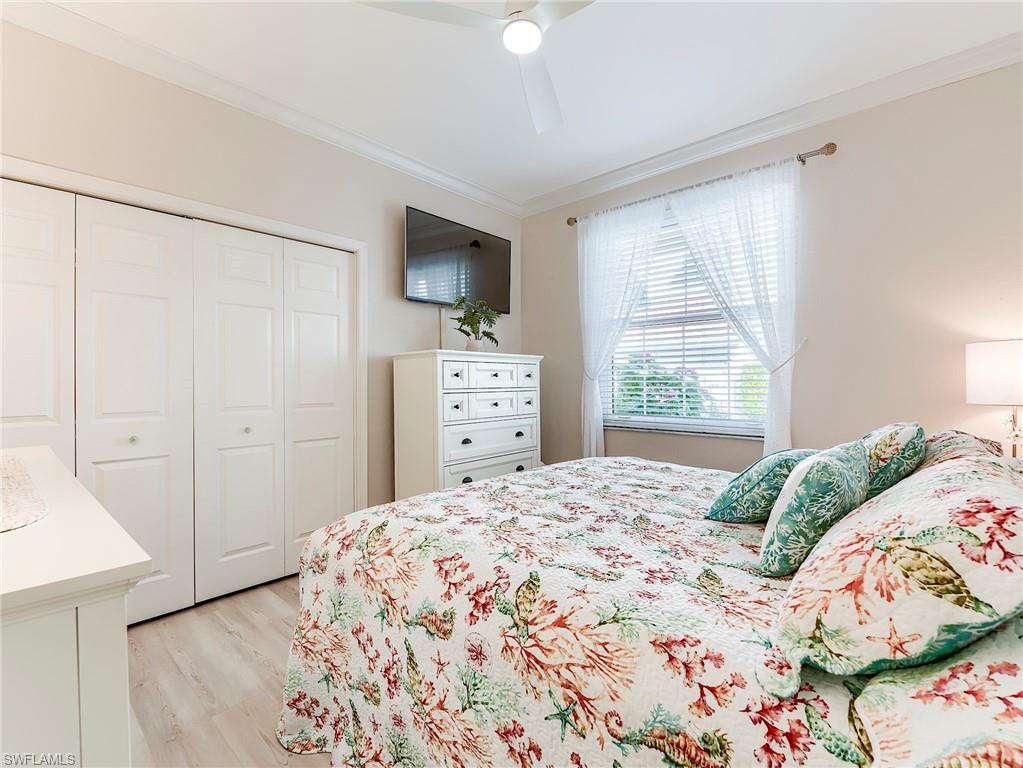 23011 Rosedale Drive, Unit 101 Estero, FL 34135 - Photo 29 of 34 a bedroom with a bed and a flat screen tv