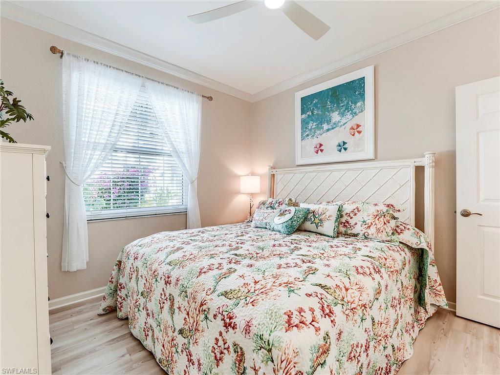 23011 Rosedale Drive, Unit 101 Estero, FL 34135 - Photo 30 of 34 a bedroom with a bed and a painting on the wall