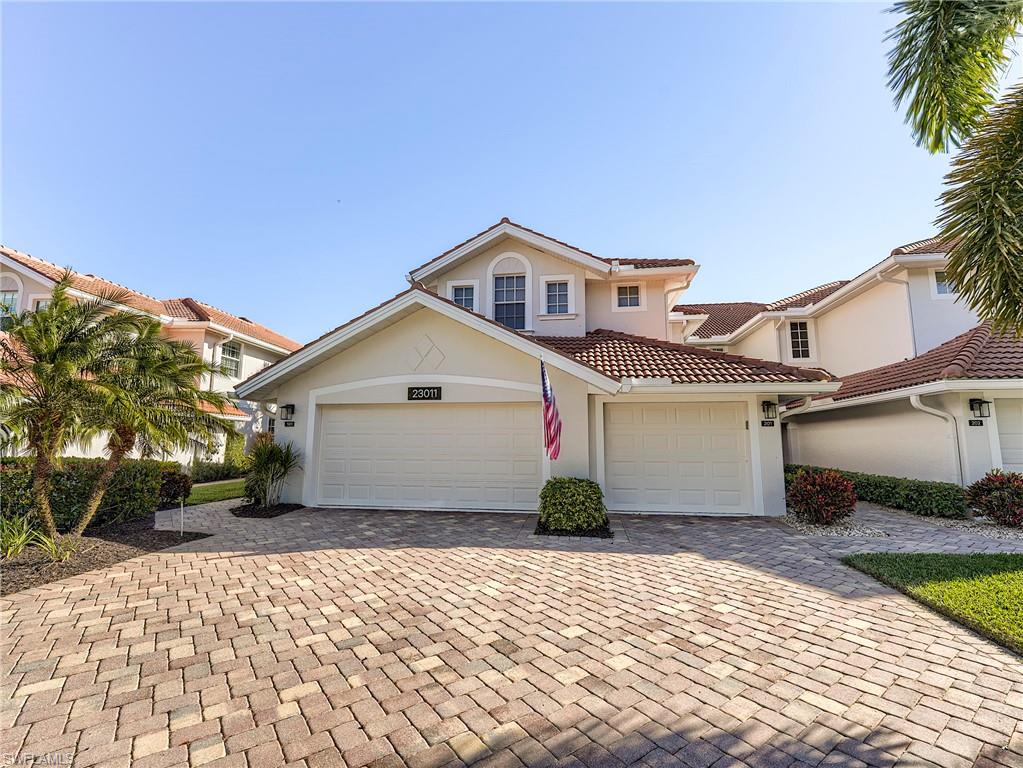 23011 Rosedale Drive, Unit 101 Estero, FL 34135 - Photo 34 of 34 a front view of a house with a yard and garage