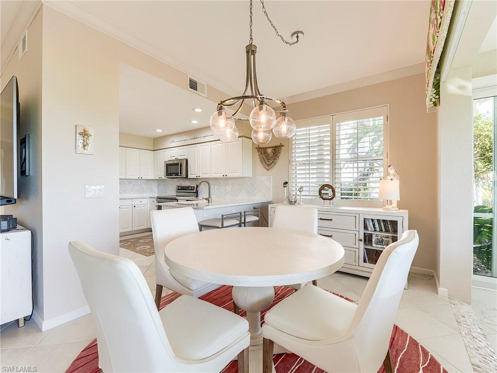 23011 Rosedale Drive, Unit 101 Estero, FL 34135 - Photo 10 of 34 a view of a dining room with furniture large window and wooden floor