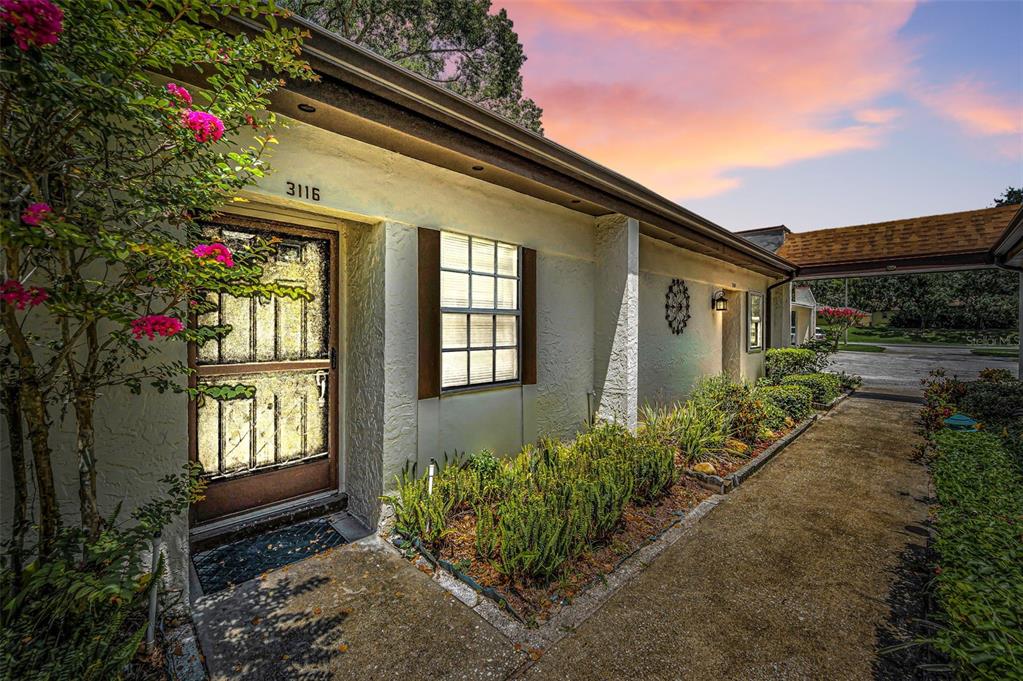3116 Highlands Boulevard, Unit 3116 Palm Harbor, FL 34684 - Photo 2 of 56 a flower garden is sitting in front of a house