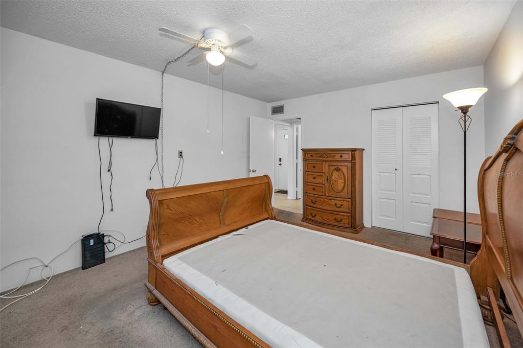 3116 Highlands Boulevard, Unit 3116 Palm Harbor, FL 34684 - Photo 22 of 56 a bedroom with a bed and a flat screen tv