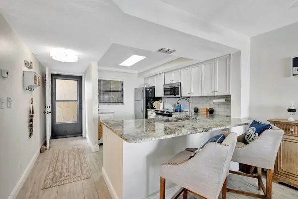 a kitchen with stainless steel appliances granite countertop a stove refrigerator sink and cabinets