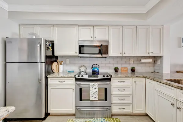 a kitchen with stainless steel appliances white cabinets and a refrigerator