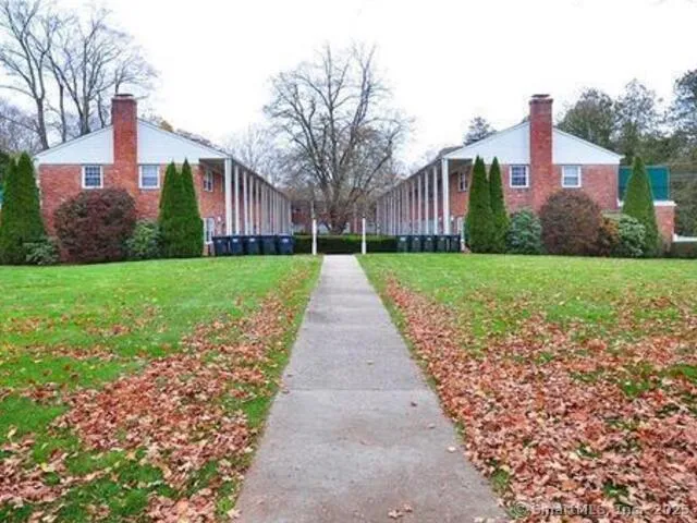 a front view of a house with a yard and potted plants