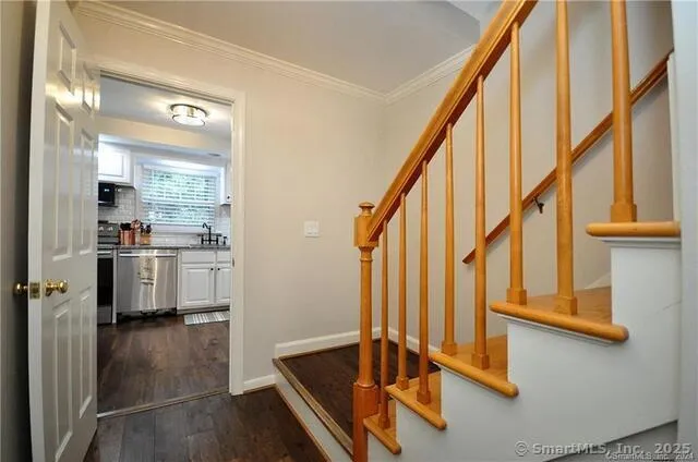 a view of front door with hallway and wooden floor