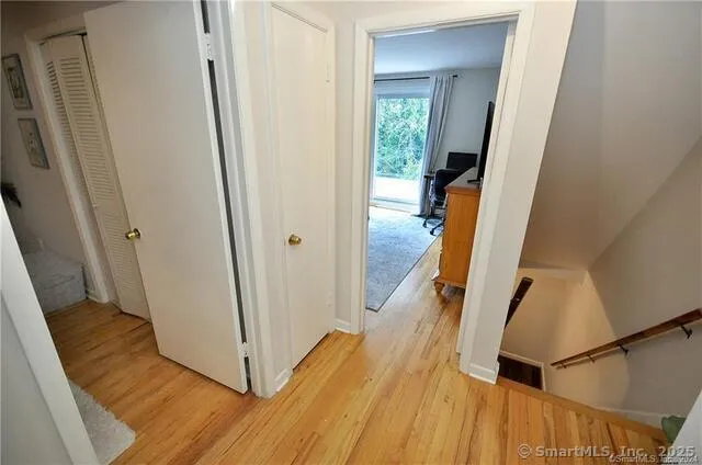 a view of a hallway with wooden floor and staircase