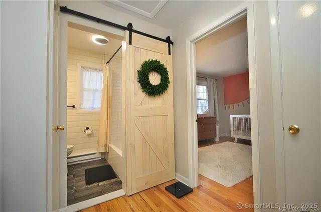a view of a hallway with wooden floor and living room