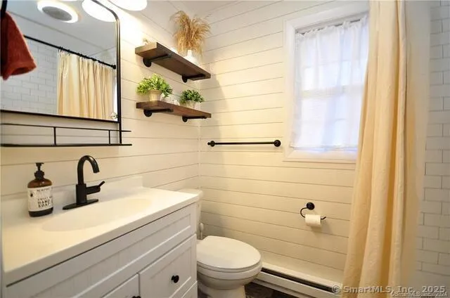 a bathroom with a sink a toilet and shower curtain