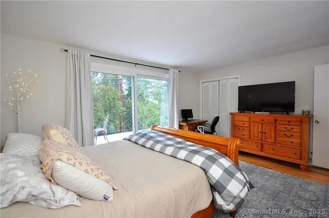 a bedroom with a bed and a flat screen tv on dresser