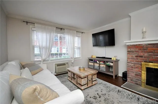 a living room with furniture a flat screen tv and a fireplace