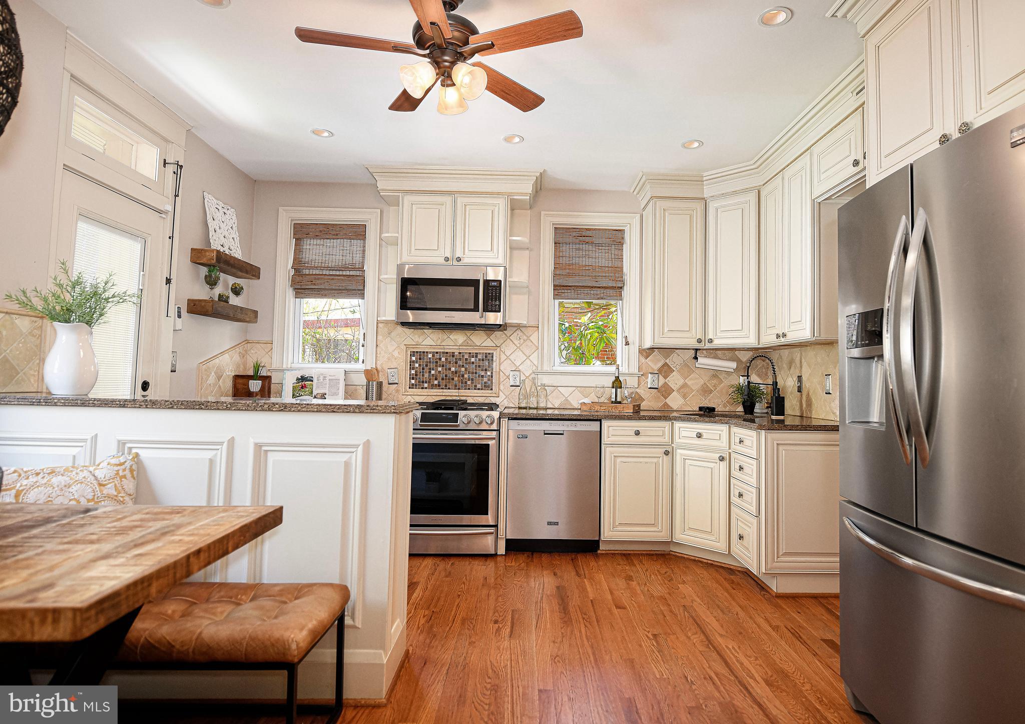 722 Anneslie Road Baltimore, MD 21212 - Photo 14 of 46 a kitchen with stainless steel appliances granite countertop a refrigerator a stove a sink dishwasher a stove with white cabinets and wooden floor
