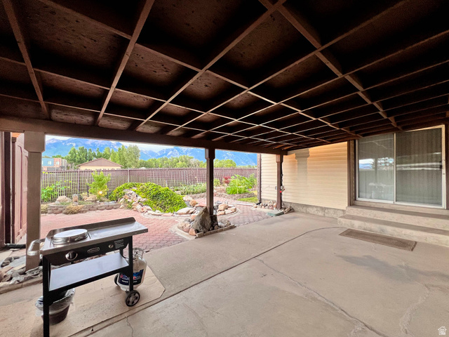 8097 South 535 East Sandy, UT 84070 - Photo 8 of 15 Covered patio featuring an exposed rafter ceiling, concrete flooring, and a sliding glass door