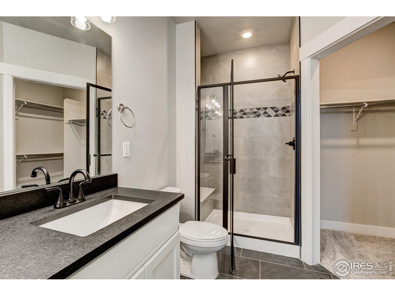 265 High Point Drive, Unit 203 Longmont, CO 80504 - Photo 11 of 24 a bathroom with a granite countertop sink mirror vanity and toilet