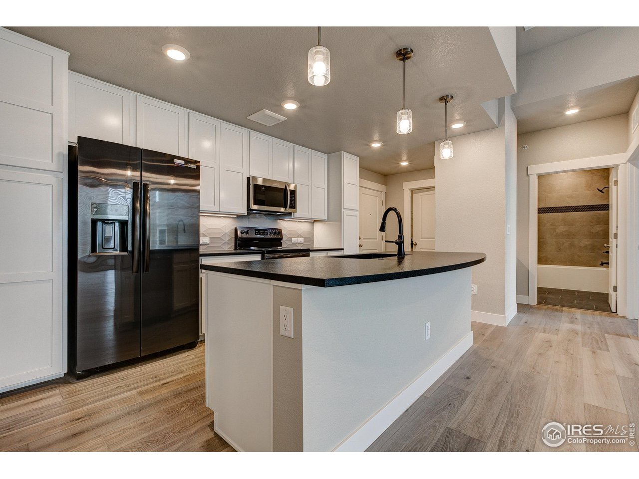 265 High Point Drive, Unit 203 Longmont, CO 80504 - Photo 2 of 24 a kitchen with kitchen island a sink stainless steel appliances and cabinets