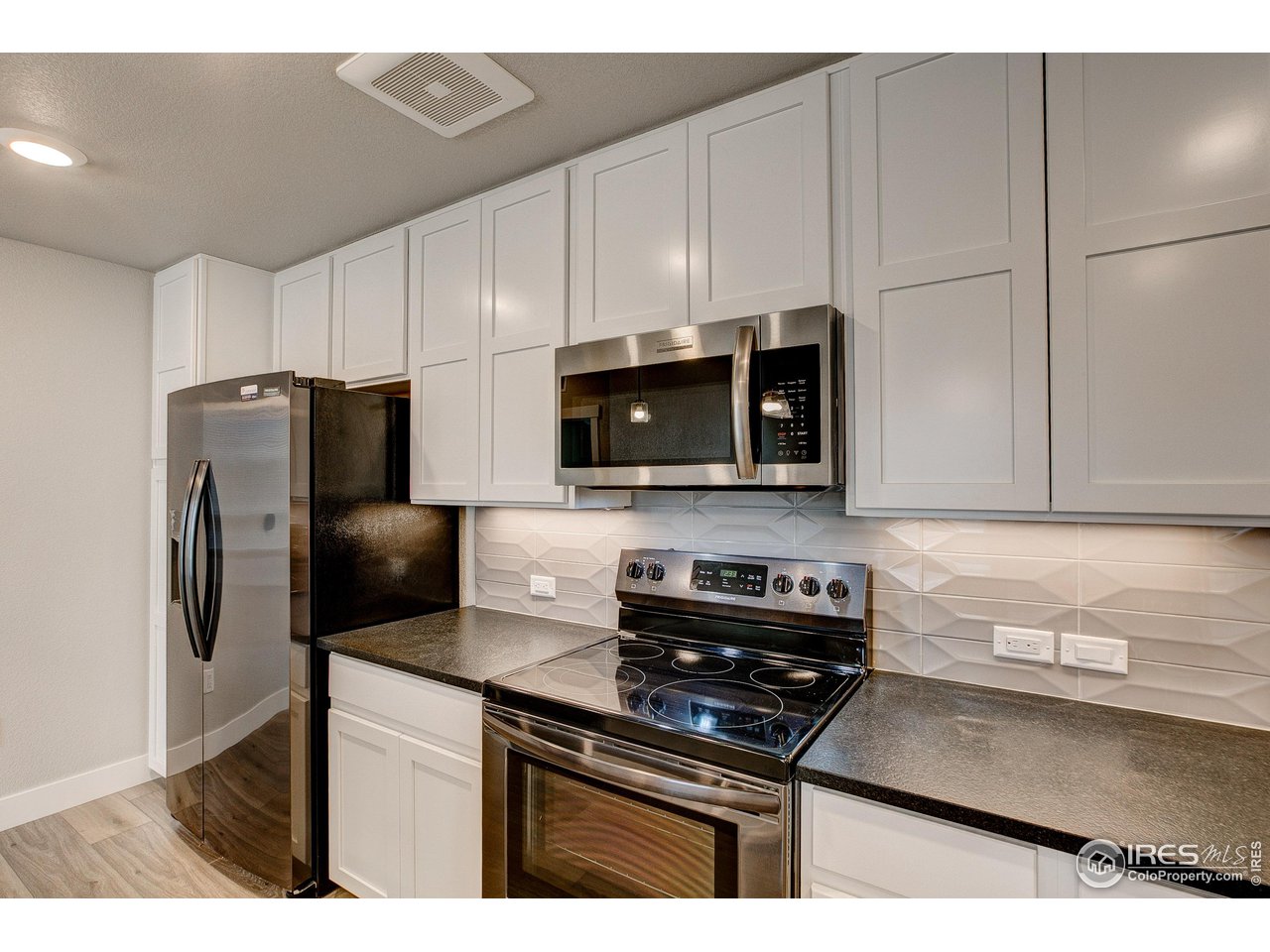 265 High Point Drive, Unit 203 Longmont, CO 80504 - Photo 3 of 24 a kitchen with stainless steel appliances a refrigerator a stove a microwave and cabinets