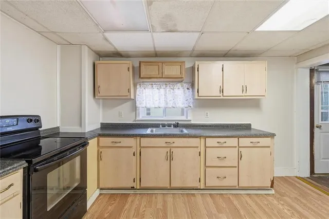 a kitchen with granite countertop white cabinets and a sink