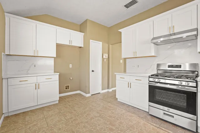 a kitchen with white cabinets and white appliances