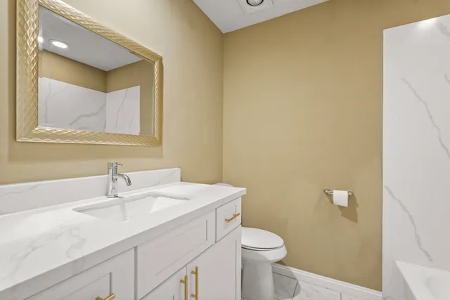 a bathroom with a sink a toilet and mirror