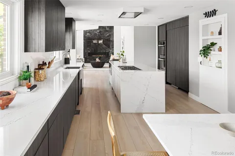 a living room with stainless steel appliances furniture wooden floor and a view of kitchen