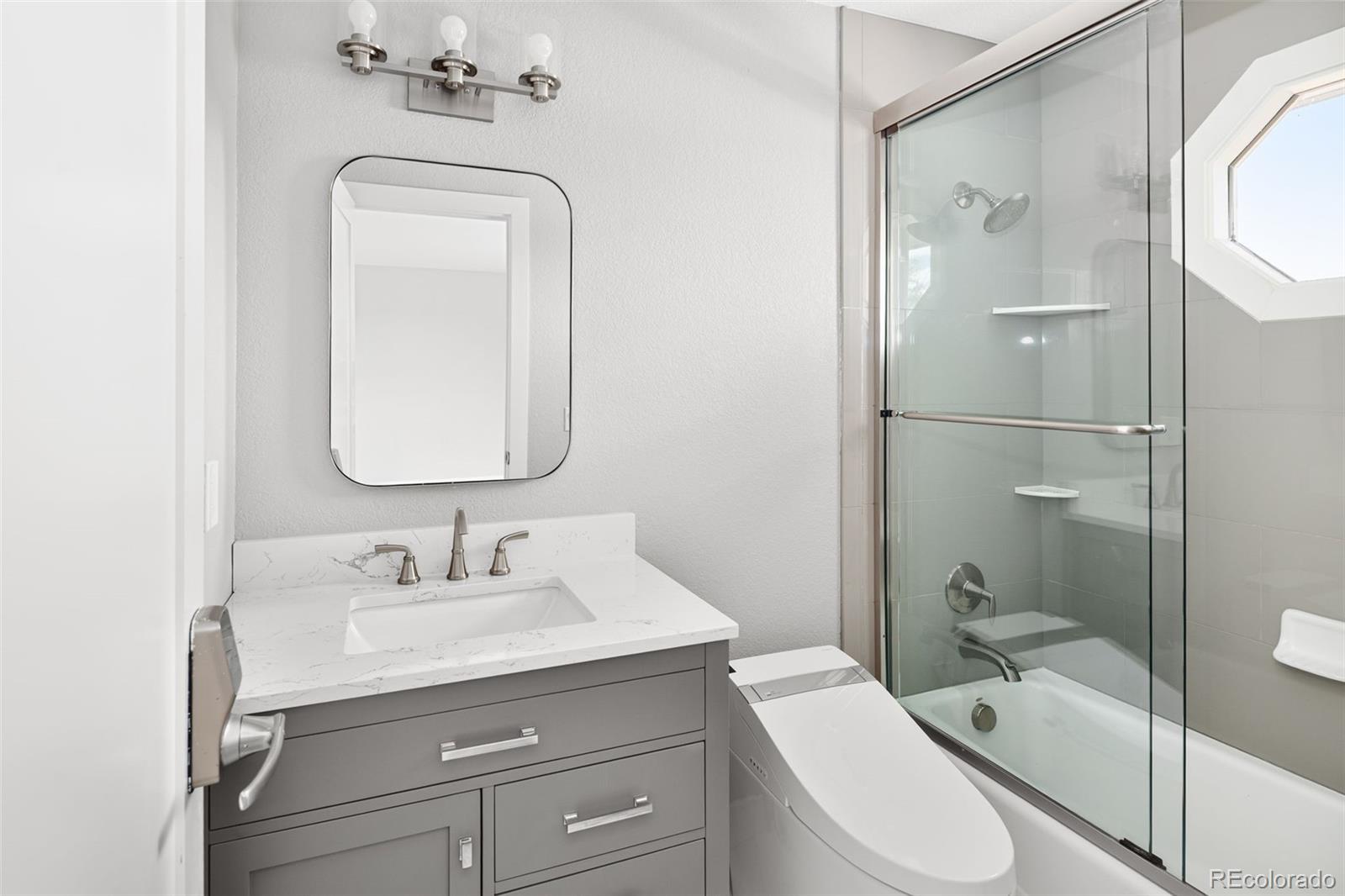 7400 South Genoa Circle Centennial, CO 80016 - Photo 32 of 50 a bathroom with a toilet a sink a tub and mirror