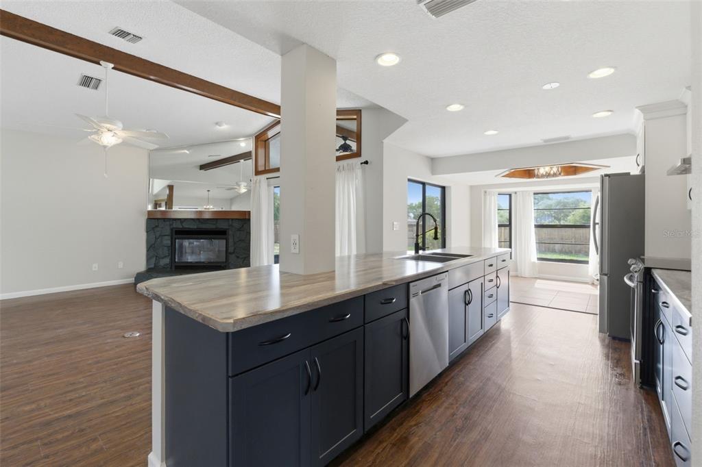 4966 Keysville Avenue Spring Hill, FL 34608 - Photo 16 of 48 a large kitchen with stainless steel appliances a large counter top a stove a chimney a sink and a refrigerator