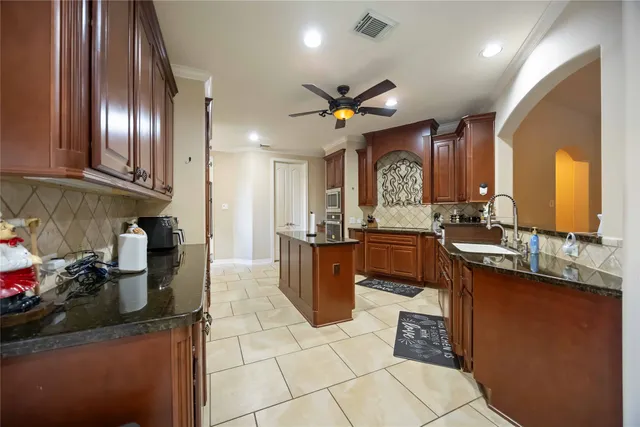 a large kitchen with a counter space a sink stainless steel appliances and cabinets