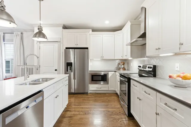 a kitchen with white cabinets and stainless steel appliances