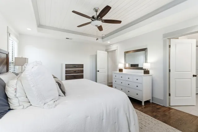 a bedroom with a bed a dresser and a chandelier