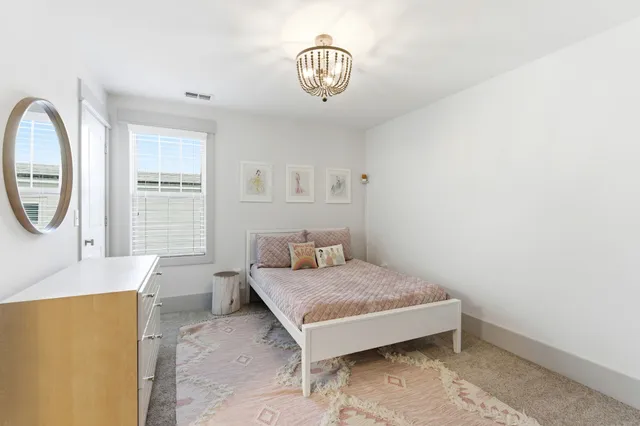 a bedroom with a bed lamp and a window