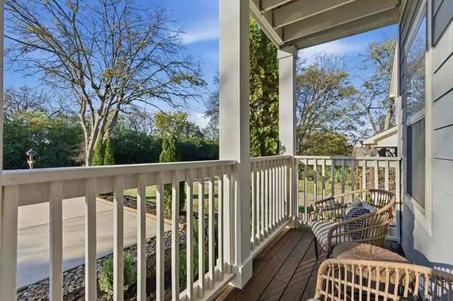 a view of a balcony with wooden floor and outdoor seating