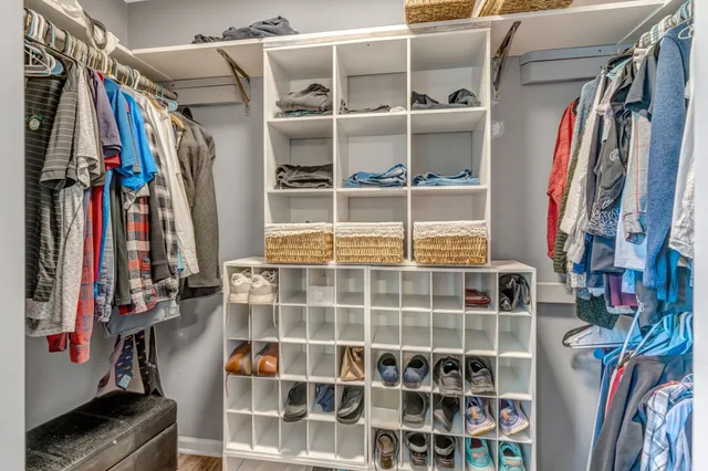 a view of walk in closet with clothes and shoes