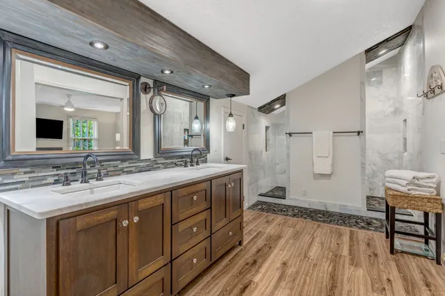 a spacious bathroom with a granite countertop sink mirror and a shower