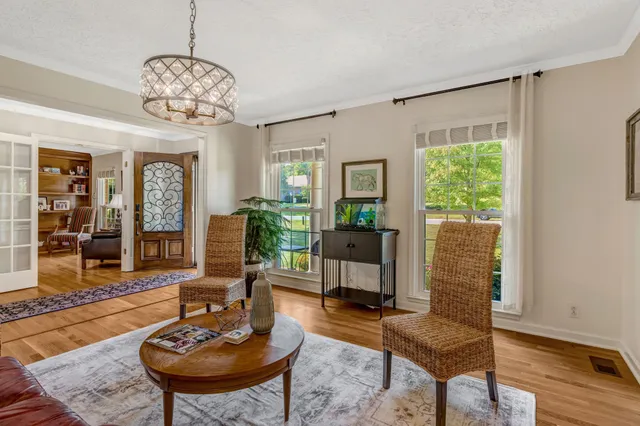 a living room with furniture a chandelier and a window